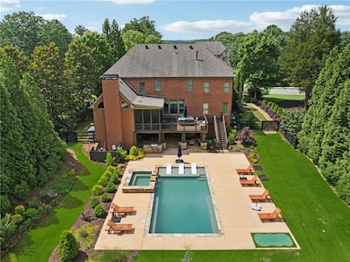 Rear view of property featuring a fenced backyard, a pool with connected hot tub, a patio, and stairway