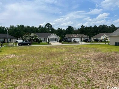 View of grassy yard with concrete driveway, a residential view, and central AC