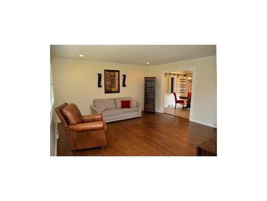 spacious living room w/ dark hardwoods