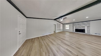 Unfurnished living room featuring ceiling fan, lig