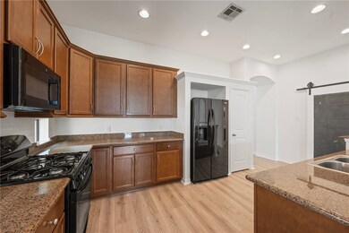 Kitchen featuring black appliances, light wood fin