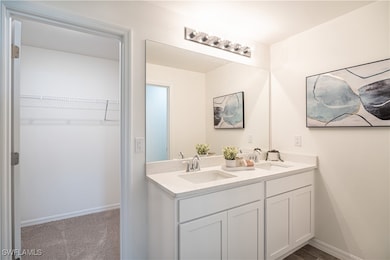 Full bath featuring a sink, baseboards, double van