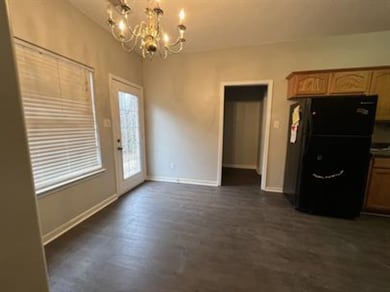 Kitchen with freestanding refrigerator, a chandelier, and dark wood finished floors