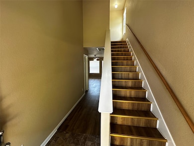 Stairs with a textured wall and a towering ceiling