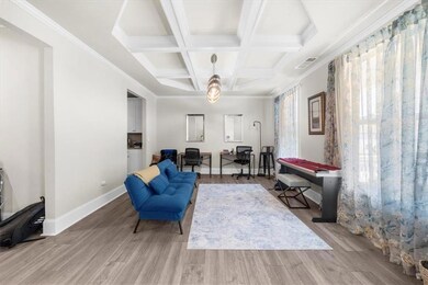 Sitting room featuring coffered ceiling, wood finished floors, and beamed ceiling