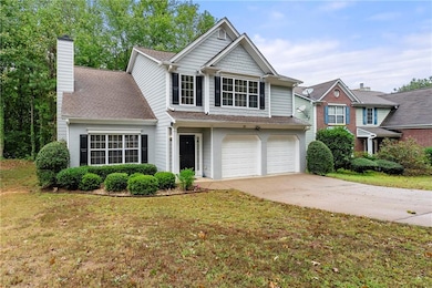 View of front of property with driveway, an attached garage, a chimney, a shingled roof, and a front lawn