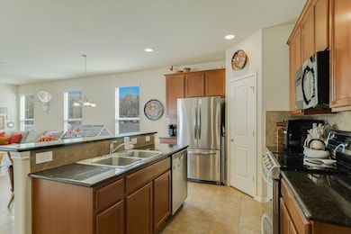 Kitchen with appliances with stainless steel finishes, recessed lighting, decorative light fixtures, and light tile patterned floors