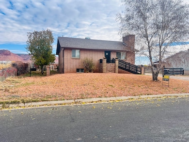 View of front of home with brick siding, a deck with mountain view, a chimney, and a shingled roof