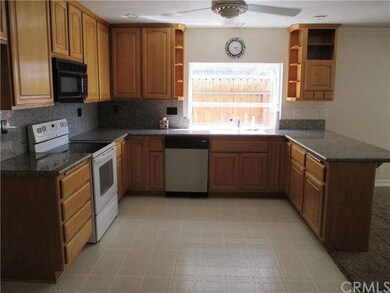 Kitchen with granite counters and garden window.