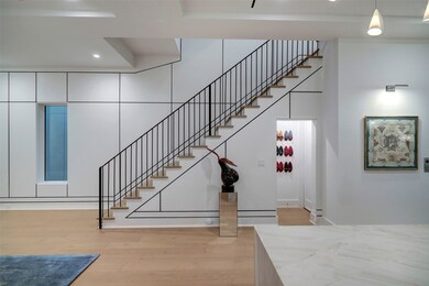 The staircase, featuring a sleek metal railing, cu