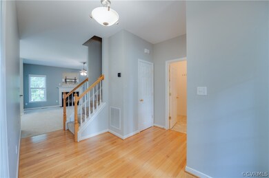 Inside is hardwood flooring.  View is inside the enrty way.  The door to the right takes into the laundry room.
