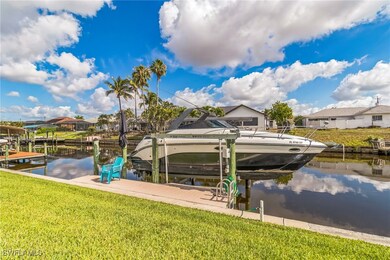 Dock area with boat lift, a water view, a lawn, an