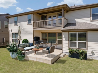 Back of property featuring a balcony, an outdoor 
