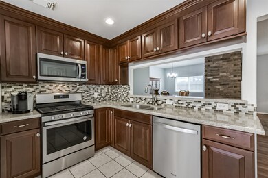 This kitchen features rich wood cabinetry, stainle