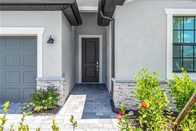Entrance to property featuring stucco siding, stone siding, and a garage