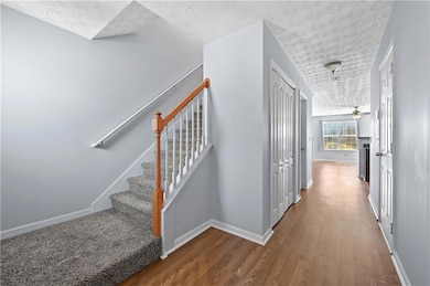 Staircase featuring wood finished floors, a ceilin