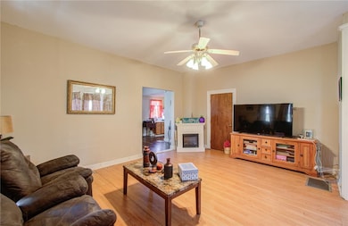 Living room featuring ceiling fan and light hardwo