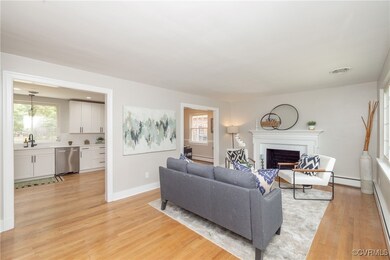 Living room featuring a brick fireplace, a baseboa