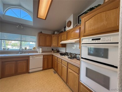 Kitchen featuring under cabinet range hood, a sink