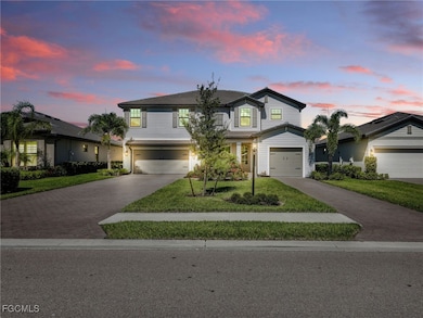 Traditional-style house featuring decorative driveway, a yard, and an attached garage