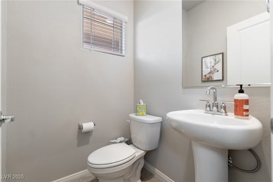 Half bath featuring toilet and baseboards