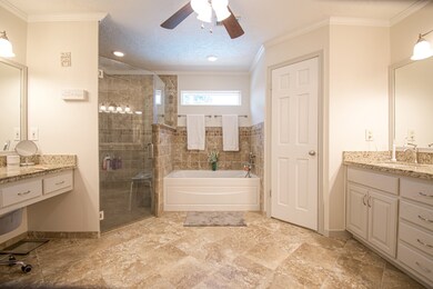Master bathroom featuring double sinks, a vanity, large shower, soaking tub, and 2 walk in closets.