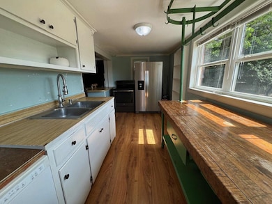 Galley style kitchen with new appliances. Windows surround the kitchen