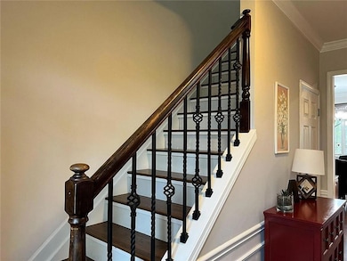 Stairway with ornamental molding and baseboards