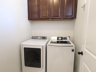 Clothes washing area featuring cabinet space and 