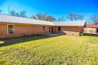 Back of property with a lawn and a patio