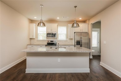 Kitchen featuring white cabinets, appliances with 