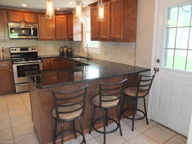Kitchen has granite countertop, tile flooring and 
