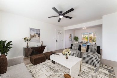 Living room featuring a ceiling fan and wood finis