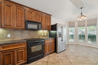 The kitchen features large tile flooring that exte