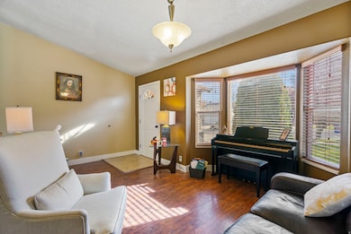 Living room featuring vaulted ceiling, wood finished floors, and a textured ceiling