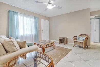 Tiled living room featuring ceiling fan