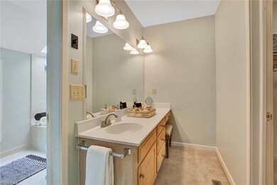 Master Bathroom: Room features include carpet and tile flooring for easy cleaning, an oversized single vanity with makeup desk. To the right side is a nice walk-in closet with access to the walk-in attic and stairs, the jetted garden tub separate shower and a window and skylight.