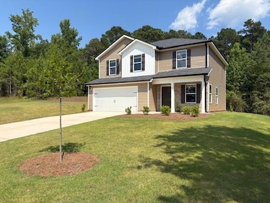 Traditional-style house with driveway, a garage, a front yard, and board and batten siding