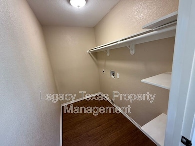 Laundry room with a textured wall, hookup for a washing machine, wood finished floors, and electric dryer hookup