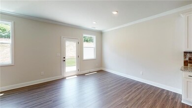 Unfurnished living room with crown molding, basebo