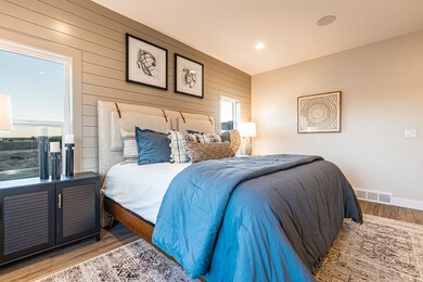 Bedroom featuring wood walls, wood finished floors, multiple windows, and recessed lighting