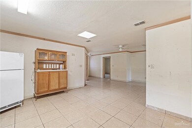 Kitchen with ceiling fan, crown molding, a textured ceiling, and white refrigerator