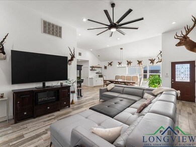 Living room featuring ceiling fan, light wood-type