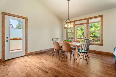 Dining area featuring wood finished floors and high vaulted ceiling