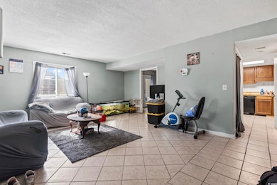 Living area with a textured ceiling and light tile