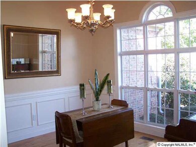 Custom palladium window in dining room with wainscoting and chair rail are some of the details that make this home special.