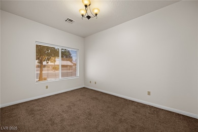 Spare room featuring dark carpet, visible vents, b