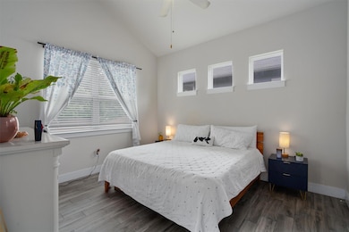 Bedroom with lofted ceiling, wood finished floors