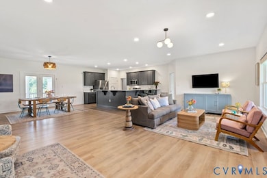 Living room with light wood-type flooring and recessed lighting