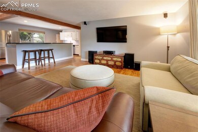 Living area with light wood-style floors, beam ceiling, and recessed lighting